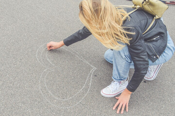 the beautiful girl in love on the road draws a heart
