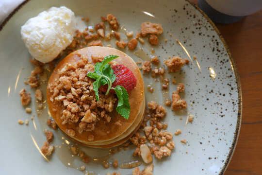 Vanilla crumb pencakes with ice cream and topping strawberry. top view