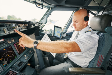 Experienced aviator checking flight controls before the departure
