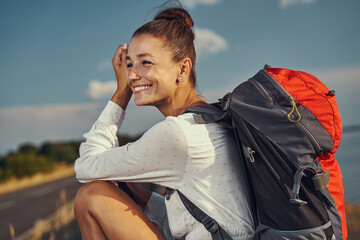 Happy person sitting in nature during hiking tour