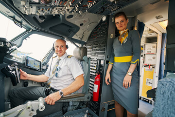 Pleased pilot and a lovely stewardess posing for the camera © Svitlana