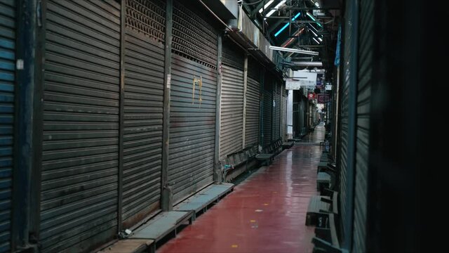 Metal roller shutter door of store in flea market is closed and locked in dark light due Coronavirus Pandemic lockdown, Economic downturn.