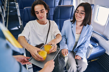 Couple being served a beverage in the first class cabin