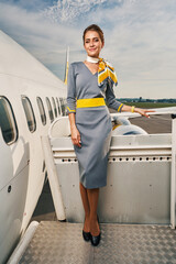 Contented attractive elegant stewardess posing for the camera