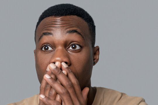 Dark-skinned young man looking surprised and shocked