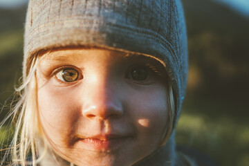 Child face eyes looking at camera cute girl portrait 2 years old toddler outdoor baby smiling wearing hat - obrazy, fototapety, plakaty