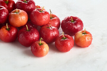 Acerolas em close com gotículas de água na diagonal