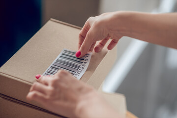 Skilled Caucasian saleslady preparing goods for shipping