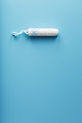 Hygienic tampon on a blue background with a free space