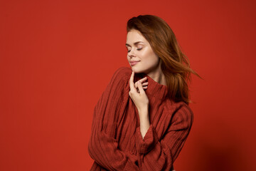 red-haired woman in red sweater fashion studio posing