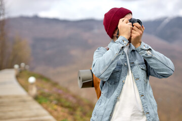 Close-up Portrait of unrecognizable traveler man taking photo of nature landscapes, in nature, at adventure alone, side view. male in denim casual jacket, in mountains