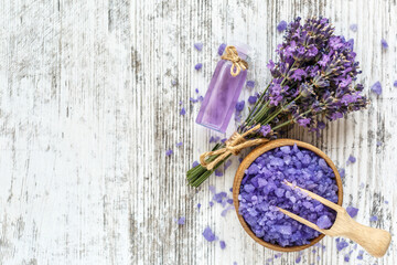 lavender's spa products with dried lavender flowers on a wooden table. Flat lay bath salt and massage oil on wooden background. Skin care, beauty treatment concept. Lavendula oleum