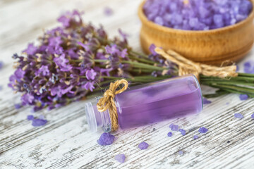 Obraz na płótnie Canvas lavender's spa products with dried lavender flowers on a wooden table. Flat lay bath salt and massage oil on wooden background. Skin care, beauty treatment concept. Lavendula oleum