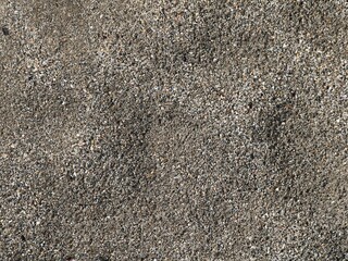 sandy background full frame, river sand from small stones of different natural shades, sand surface texture with uneven texture and empty space
