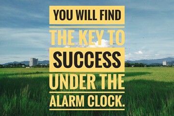 You will find the key to success under the alarm clock. Motivational quote isolated in paddy fields scenery.