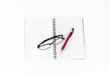 Concept Education or business : Top view of Open diary or note book with modern glasses and red pen isolated on white background. .