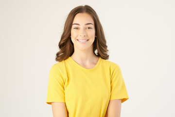 Obraz premium cheerful brunette in yellow t-shirts Studio light background