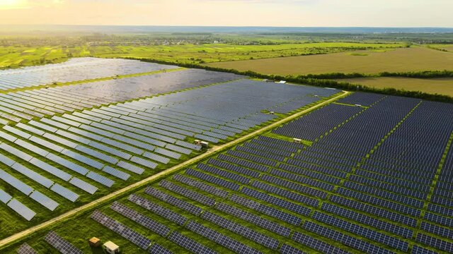 Aerial view of big sustainable electric power plant with rows of solar photovoltaic panels for producing clean ecological electrical energy in morning. Renewable electricity with zero emission concept