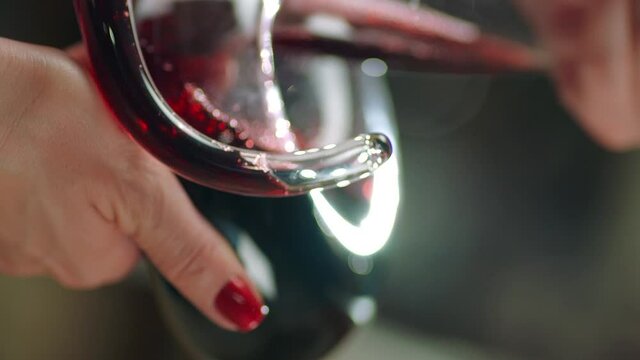 Sommelier pouring red wine from bottle into decanter . Close-up footage of wine mixing process in carafe . Preparation process to degustation of wine. Shot on RED HELIUM Cinema Camera in Slow Motion.