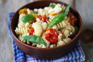 Feta tomato pasta in a bowl. Italian style cuisine.