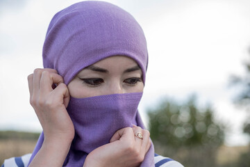 An Afghan woman with downcast eyes in a hijab. Women in Kabul are forced to wear a hijab and a...
