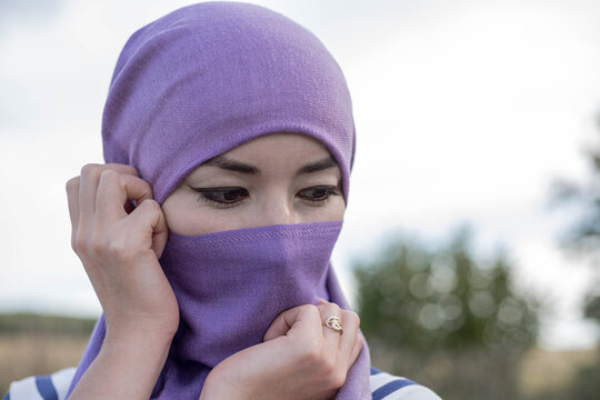 An Afghan woman with downcast eyes in a hijab. Women in Kabul are forced to wear a hijab and a burka. The rise to power of the Taliban. Violation of women's