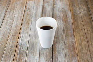 A view of a black coffee inside a white styrofoam cup.