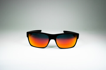 Product photo of sun Glasses with orange glass and black frame on white background. Template for social media, website
