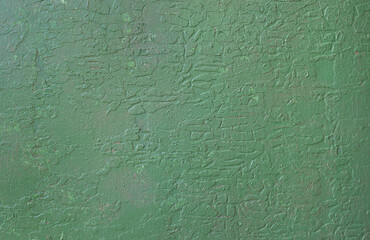 Wall with old peeling green paint.