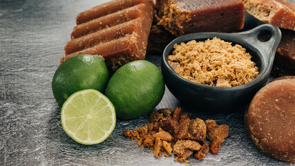 panela, from sugar cane and lemon, for different preparations on gray background, made in Colombia.