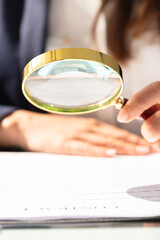 Businesswoman Looking At Contract Form Through Magnifying Glass