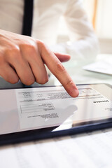 Businessperson Analyzing Invoice On Digital Tablet