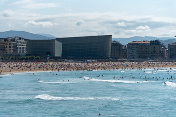 Vista de la playa de la zurriola en San Sebastian en un dia de verano con gente bañandose