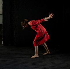 woman in a red dress on a black background dancing, waving her hands