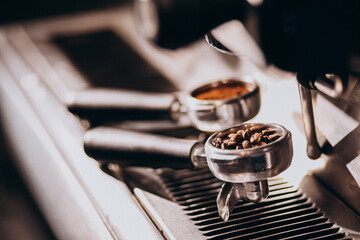 Coffee beans in a metallic cup in a coffee machine