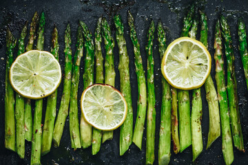 Grilled asparagus. Baked or grilled green asparagus with lemon in black cast iron pan