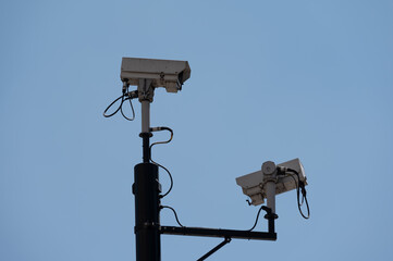 CCTV cameras against a bright blue sky