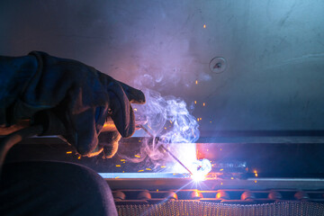 Closeup of metal welder is working with arc welding machine to weld steel for assembly structure of...