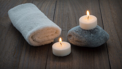 Fototapeta na wymiar Towel, stone and candles on the wooden table. Spa style. Therapy
