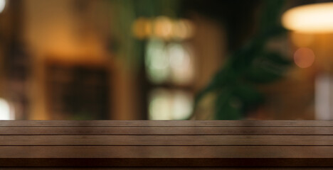 Empty wooden table top with lights bokeh on blur restaurant background.