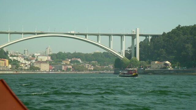 Close-Up Shot Of Vehicles Moving On Ponte Da Arr�bida Over River Amidst City During Sunny Day - Porto, Portugal