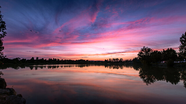 Beautiful pink sky evening beauty and clouds at sunset , Dicosa lake, France