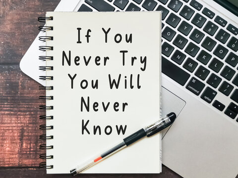 Open notebook with text "If You Never Try You Will Never Know" and a laptop on wooden background.