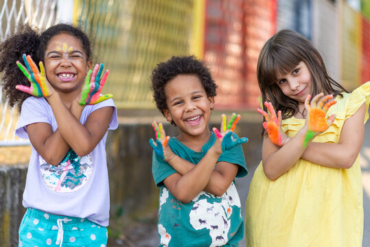 group of cheerful multicultural children showing painted hands