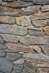 Wall of irregular stones aged. Vintage vertical background