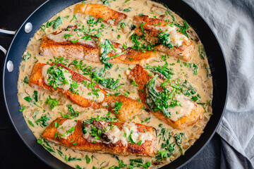 Creamy Garlic Butter Tuscan Salmon in a Skillet: Salmon fillets in a creamy parmesan sauce with...