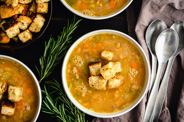 Creamy White Bean Soup with Rosemary and Pancetta: Bowls of cannellini bean soup made with vegetables, rosemary, and pancetta