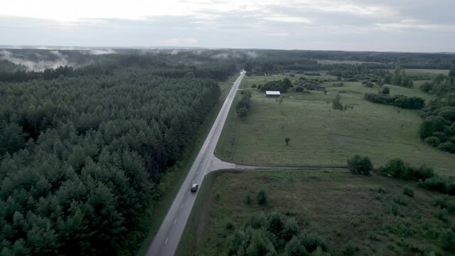 Areal view of the cars moving in fogy forest at summer 