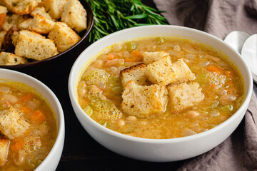 Creamy White Bean Soup with Rosemary and Pancetta: Bowls of cannellini bean soup made with vegetables, rosemary, and pancetta
