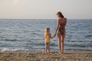 Mother and her toddler girl enjoying a day at the beach